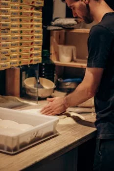 experienced chef kneading pizza dough